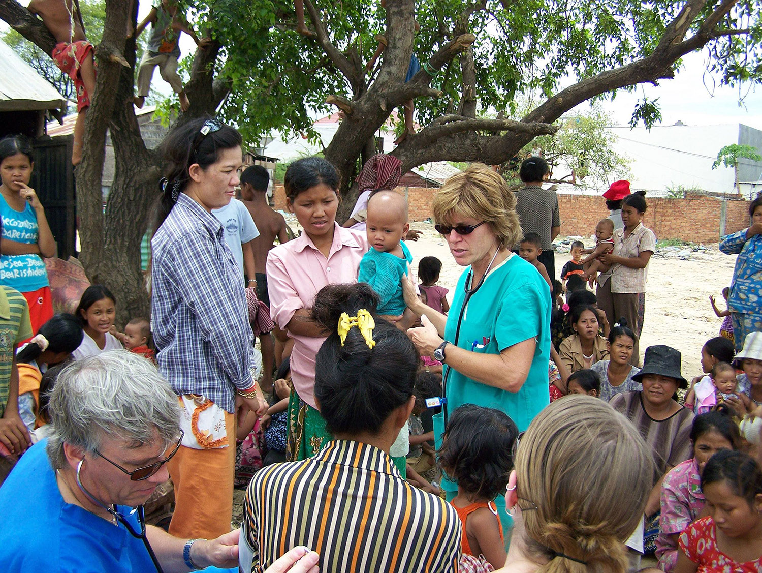 University of Michigan clinical associate professor emerita of nursing Maureen Tippen and colleague examine children at an outdoor clinic.