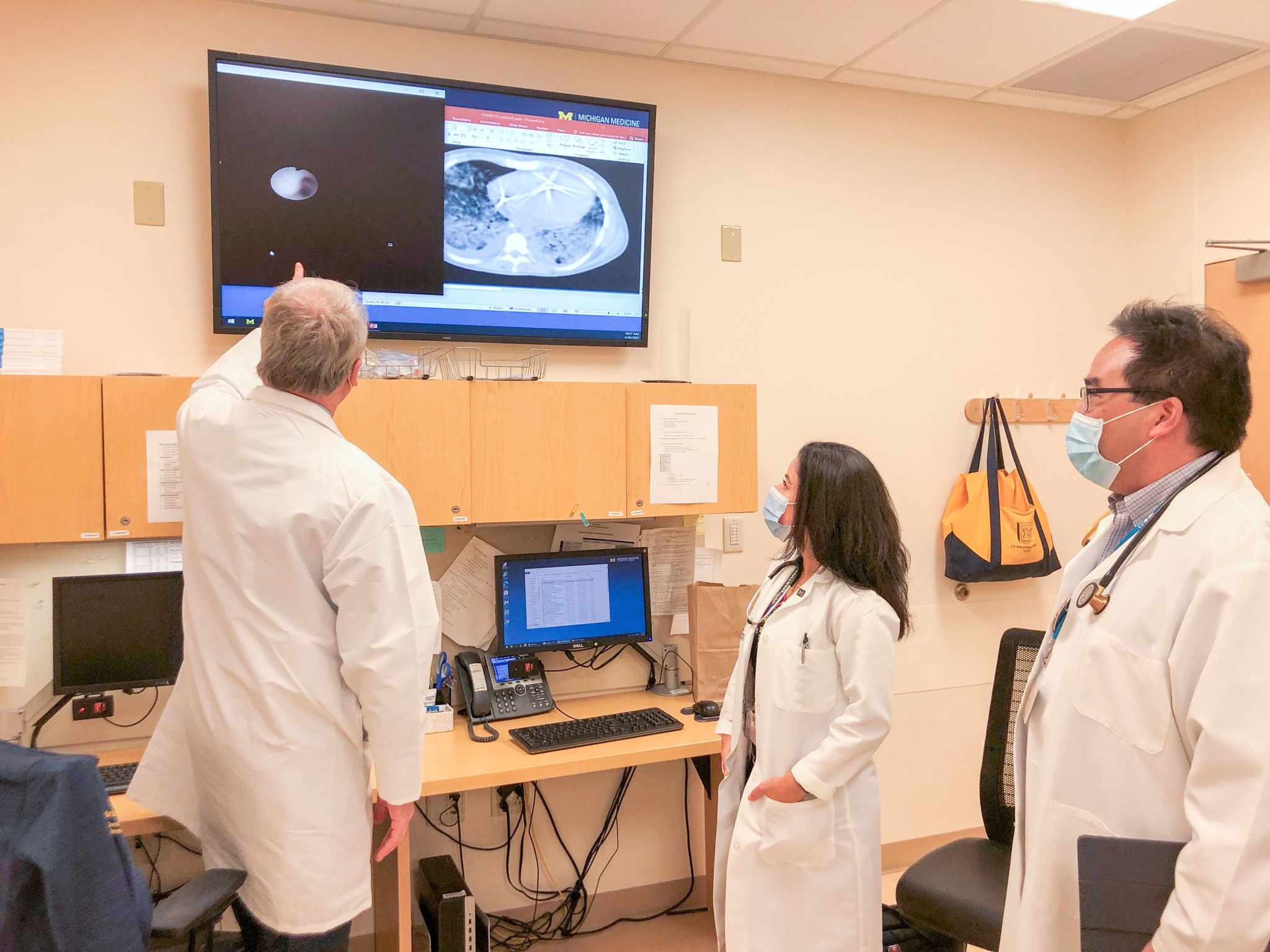 Three Michigan Medicine physicians look at images in one of the University of Michigan “long COVID” clinics